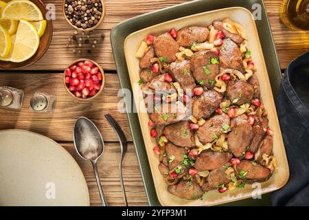 Arabische Küche; zarte Hühnerleber mit ZitronenKnoblauch und karamelisierten Zwiebeln. In einer süßen, würzigen Granatapfelglasur gekocht. Garniert mit Granatapfelkernen Stockfoto