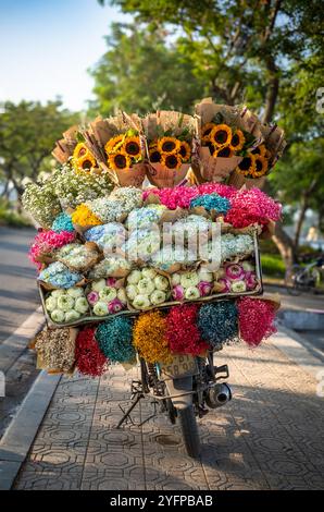 Geschenkverpackte Sträuße aus Lotus (Nelumbo nucifera), Hortensie (Hydrangeaceae), Sonnenblumen (Helianthus) und anderen Blumen zum Verkauf auf einem Motorrad in Han Stockfoto