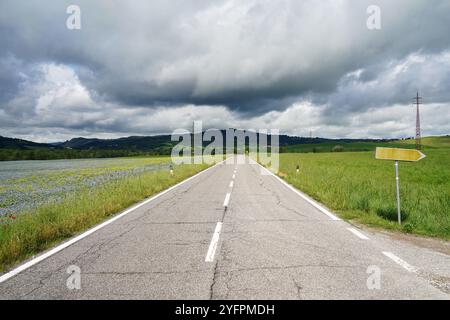 Toskanische Landschaft mit gerader Landstraße. Leere Wegweiser und bewölkt. Stockfoto