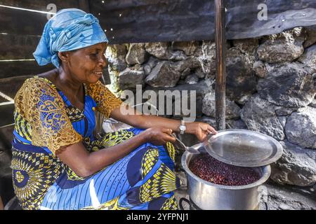 Frau sitzt und kocht in ihrer Küche in Bukavu, DRK Stockfoto