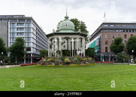 Bergen, Norwegen - 8. August 2022: Historische Art-Deco-Musikhalle umgeben von Blumen im Byparken Park im Stadtzentrum von Bergen Stockfoto