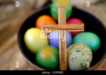 Frohe Ostern. Ostereier mit einem Holzkreuz. Die Auferstehung Christi ist der älteste und christlichste Feiertag. Stockfoto