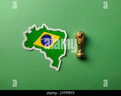 Perak, Malaysia-23. August 2024: Top View brasilianische Flaggenaufkleber mit WM-Trophäe auf grünem Hintergrund. Stockfoto