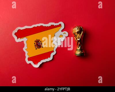 Perak, Malaysia-23. August 2024: Top View World Cup Trophäe mit spanischen Flaggenaufklebern auf rotem Hintergrund. Stockfoto