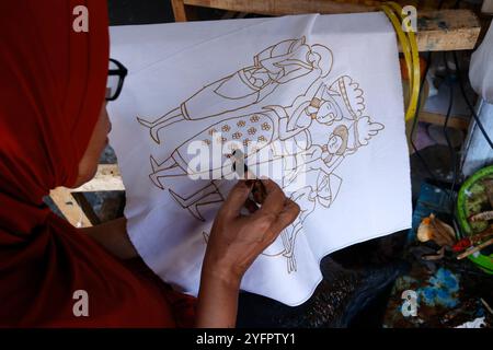 Batikproduktion. Frau, die heißes Wachs benutzt, um ein Stoffdesign zu skizzieren. Yogyakarta. Indonesien. Stockfoto