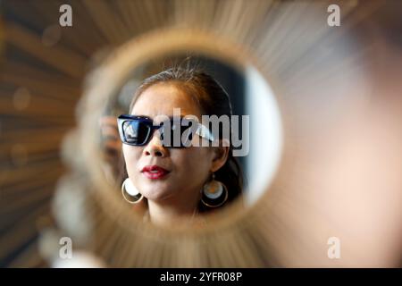 Junge Frau, die sich zu Hause im Spiegel spiegelt. Wien. Österreich. Stockfoto