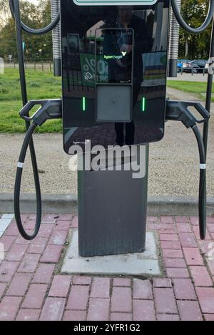 Erneuerbare Energien in den Niederlanden: Eine doppelt aufladbare EV-Ladestation mit Werbeaufkleber auf Green Planet in Pesse. Stockfoto