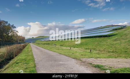 Erneuerbare Energien in den Niederlanden: Großer Solarpaneelpark auf einer umgenutzten Deponie, der die Integration erneuerbarer Energien mit grüner Landschaft unter zeigt Stockfoto