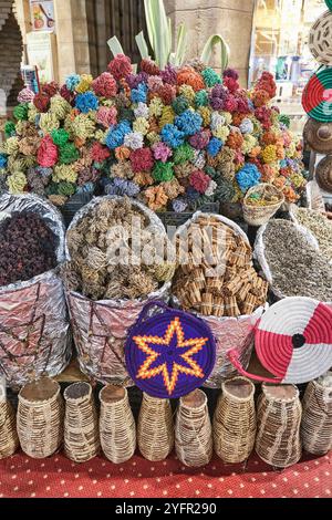 Souvenirs für Touristen auf dem ägyptischen Markt. Getrocknete, bemalte Pflanzen aus dem Herzen der Wüste, Hand Marias. Zimtstangen, trockene arabische Gewürze in Körben, Hand Stockfoto