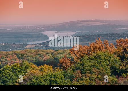 Panoramablick auf die Donau, die sich durch den Herbstwald schlängelt, mit leuchtenden Herbstfarben und üppigem Grün Stockfoto