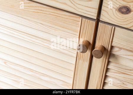 Holztüren mit Lamellen und Holzgriff in Nahaufnahme. Die Türen der Außenküche sind aus hellem Kiefernholz mit natürlichem Masermuster gefertigt Stockfoto