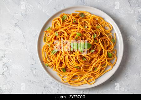 Pasta-Spaghetti-Bolognese mit Hackfleischsoße, Tomaten, Parmesan und frischem Basilikum auf einem Teller Stockfoto