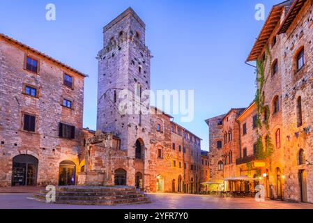 San Gimignano, Italien. Piazza della Cisterna mit dreieckiger Form, mittelalterliche Stadt auf einem Hügel in der Toskana, Szene im Dämmerungslicht. Stockfoto