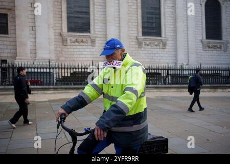 Am 4. November 2024 in London, England, fährt ein Radfahrer mit dem Fahrrad an der St Paul's Cathedral vorbei, mit einem Schild mit der Aufschrift Jesus im Mund. Stockfoto