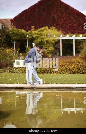 Schönes junges Paar, das sich im Herbst draußen küsst. Liebevolles Paar, das in der Natur spaziert. Herbststimmung. Glückliche Männer und Frauen, die sich im Herbst umarmen und küssen. Liebe. Stockfoto