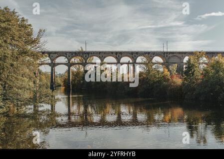 Eisenbahnbrücke mit Fluss in Bietigheim-Bissingen, Deutschland. Herbst. Eisenbahnviadukt über der Enz, erbaut 1853 von Karl von Etzel auf sonniger Basis Stockfoto