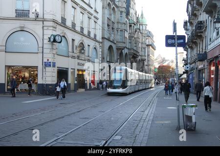 Eine Straßenbahn fährt entlang der Rue de la Mesange, einer Einkaufsstraße voller Touristen in Straßburg, Frankreich, 2024 Stockfoto