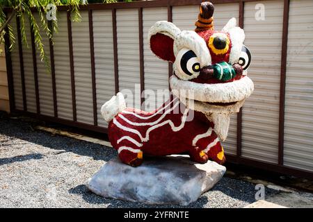 Skulptur Schnitzerei alte Steinfigur Cartoon Löwentanz traditionelle chinesische Kulturstatue im Garten im Vihara Ariya Guan Yu in Antique C Stockfoto