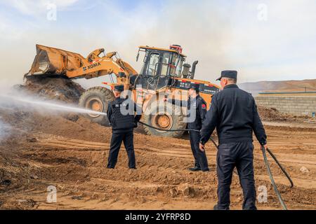 ALTAY, CHINA - 5. NOVEMBER 2024 - Grenzpolizisten löschten am 5. November 2024 ein Feuer auf einem Heuhaufen in einem Hirtenheim in Altay, Provinz Xinjiang, China. Stockfoto