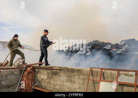 ALTAY, CHINA - 5. NOVEMBER 2024 - Grenzpolizisten löschten am 5. November 2024 ein Feuer auf einem Heuhaufen in einem Hirtenheim in Altay, Provinz Xinjiang, China. Stockfoto