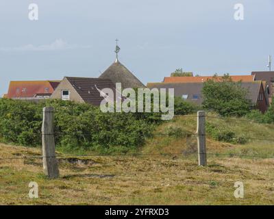 Blick auf ein kleines Dorf mit roten Dächern und grüner Vegetation im Vordergrund, baltrum, ostfriesland, deutschland Stockfoto