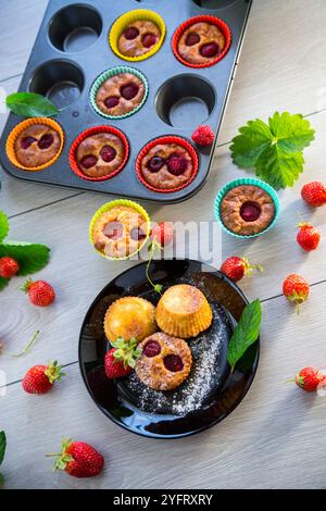Süße Quark-Muffins mit Erdbeerfüllung, auf einem Teller auf einem Holztisch. Stockfoto