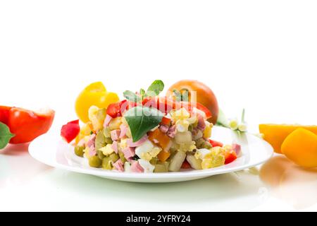 Gemüsesalat aus gekochtem Gemüse, mit Erbsen, Wurst, süßem Pfeffer. Isoliert auf weißem Hintergrund. Stockfoto