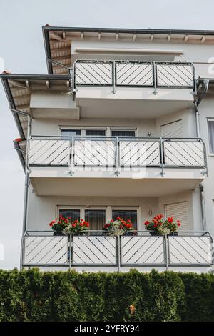 Modernes Äußeres eines luxuriösen Privathauses. Teil der Fassade. Reflexion in Fenstern. Balkon. Wunderschönes Strandhaus mit Balkonen und Bäumen im Freien. Idyl Stockfoto