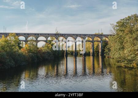 Eisenbahnbrücke mit Fluss in Bietigheim-Bissingen, Deutschland. Herbst. Eisenbahnviadukt über der Enz, erbaut 1853 von Karl von Etzel auf sonniger Basis Stockfoto