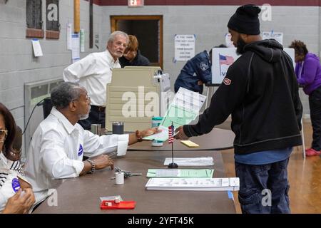 Detroit, Michigan, USA. November 2024. Ein Wähler erhält seinen Wahlzettel für die Präsidentschaftswahl 2024 kurz nach der Eröffnung der Wahlen in der Lutheran Church Bethany. Quelle: Jim West/Alamy Live News Stockfoto