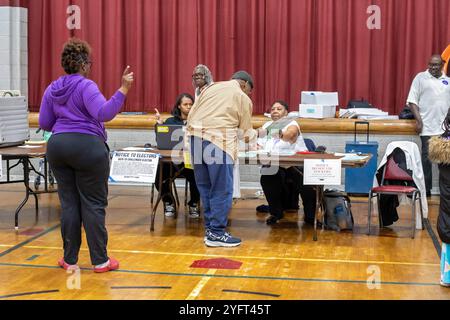 Detroit, Michigan, USA. November 2024. Ein Wähler erhält seinen Wahlzettel für die Präsidentschaftswahl 2024 kurz nach der Eröffnung der Wahlen in der Lutheran Church Bethany. Quelle: Jim West/Alamy Live News Stockfoto