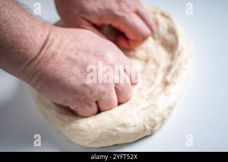 Die Hände des Pizzamakers oder Küchenchefs machen einen Kreis aus Teig für die Pizzabasis. Der Prozess der Pizza. Hochwertige Fotos Stockfoto