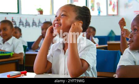 Ein Schulmädchen lächelt hell, während er am Unterricht teilnimmt. Stockfoto
