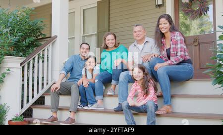 Porträt Der Multi Generation Family Sitzt Auf Stufen, Die Zur Hausterrasse Führen Stockfoto