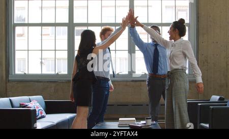 Multikulturelles Business-Team Feiert Gegenseitig High Five In Modern Office Stockfoto