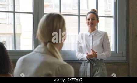 Junge Geschäftsfrau Führt Informelles Treffen Mit Weiblichem Team, Das Auf Sofas Im Modern Office Sitzt Stockfoto
