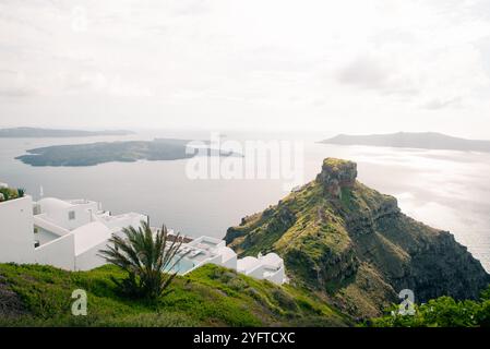 Skaros Rock im Dorf Imerovigli mit Vulkaninsel Nea Kameni im Hintergrund, Santorin, Griechenland. Hochwertige Fotos Stockfoto