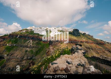 Skaros Rock im Dorf Imerovigli mit Vulkaninsel Nea Kameni im Hintergrund, Santorin, Griechenland. Hochwertige Fotos Stockfoto