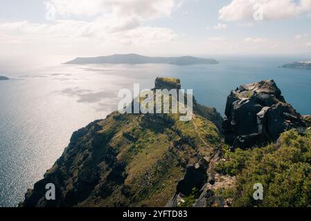 Skaros Rock im Dorf Imerovigli mit Vulkaninsel Nea Kameni im Hintergrund, Santorin, Griechenland. Hochwertige Fotos Stockfoto