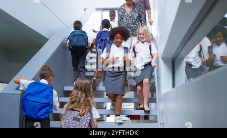 Lehrer und Schüler zu Fuß über Treppen in den Beschäftigten Volksschule Korridor Stockfoto