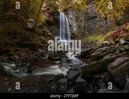 Saisonaler Herbstblick auf den Melincourt Wasserfall, den stimmungsvollen und wunderschönen hohen Wasserfall in Resolven, Südwales, Großbritannien Stockfoto