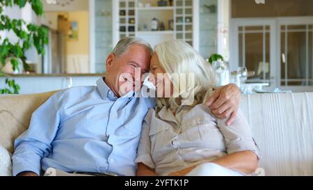 Liebevolles Seniorenpaar Umarmt Sich Zu Hause Auf Dem Sofa Stockfoto