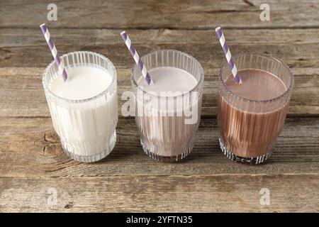 Verschiedene leckere Proteincocktails in Gläsern auf Holztisch Stockfoto