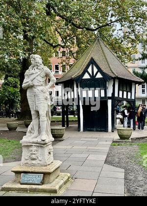 Die Statue von Karl II. Aus dem Jahr 1661 von Caius Gabriel Cibber auf dem Soho-Platz, vor dem denkmalgeschützten „Market Cross“-Gebäude, fertiggestellt im Jahr 1926. Stockfoto