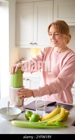 Frau Mischt Joghurt Und Frisches Obst Im Mixer Für Gesunden Smoothie In Der Küche Zu Hause Stockfoto