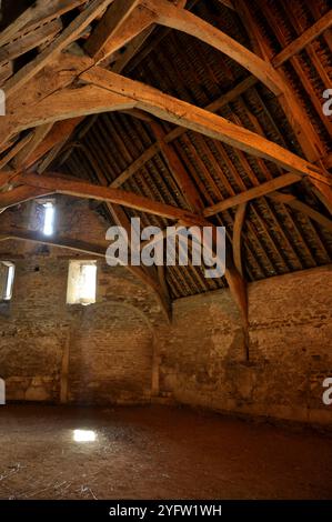 Lacock Tithe Scheune, aus Stein gebaute Scheune aus dem 14. Jahrhundert. Sonnenwellen leuchten durch den Staub vom Strohboden der Scheune. Wiltshi Stockfoto