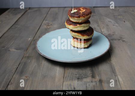 Hausgemachte Pfannkuchen, Käsekuchen werden auf einem Teller auf einem grauen Hintergrund mit Platz für Text gestapelt. Hausgemachtes Frühstück. Stockfoto