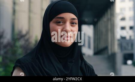 Porträt glücklich lächelnde muslimische Geschäftsfrau islamische Geschäftsfrau Mädchen weiblich in schwarzem Hijab Arbeitgeber in der Stadt zeigt einen Finger kommen mit Idee Stockfoto