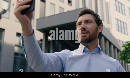 Smartphone chatten Videoanruf Konferenz App sprechende Webkamera Kaukasischer Geschäftsmann lächelnder Influencer Mann mittleren Alters Geschäftsmann männlicher Mann Stockfoto