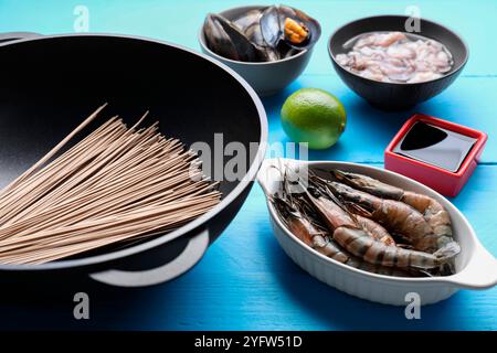 Verschiedene Zutaten für Wok auf hellblauem Holztisch Stockfoto